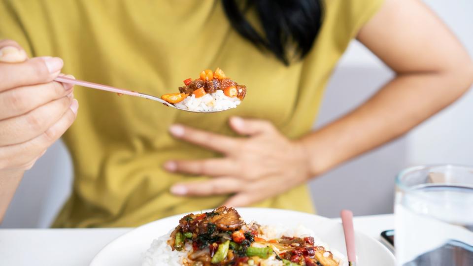 Woman enjoying a meal with a spoon.