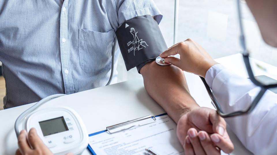 A doctor measuring a patient's blood pressure using a sphygmomanometer, ensuring their health is monitored accurately.