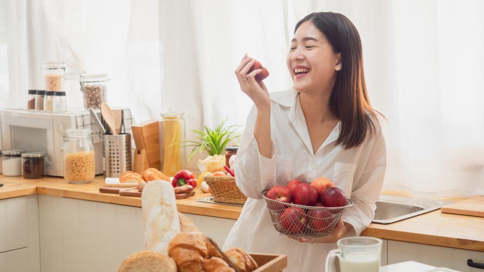 Woman enjoying a bowl of fresh fruit.