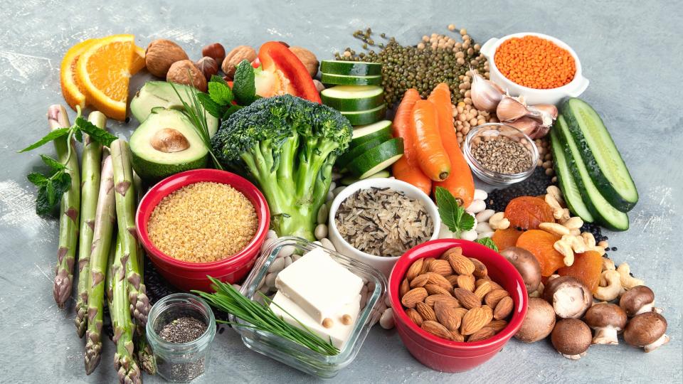 A colorful assortment of nutritious foods: broccoli, carrots, avocado, and other vegetables.