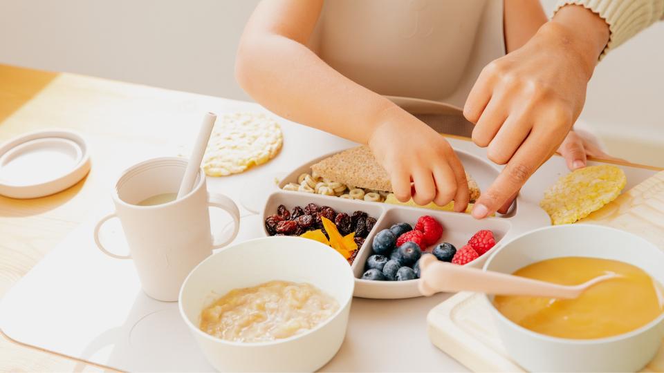 Child eating a meal with a spoon.