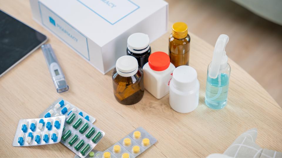 A table with a tablet, pills, and medical supplies.