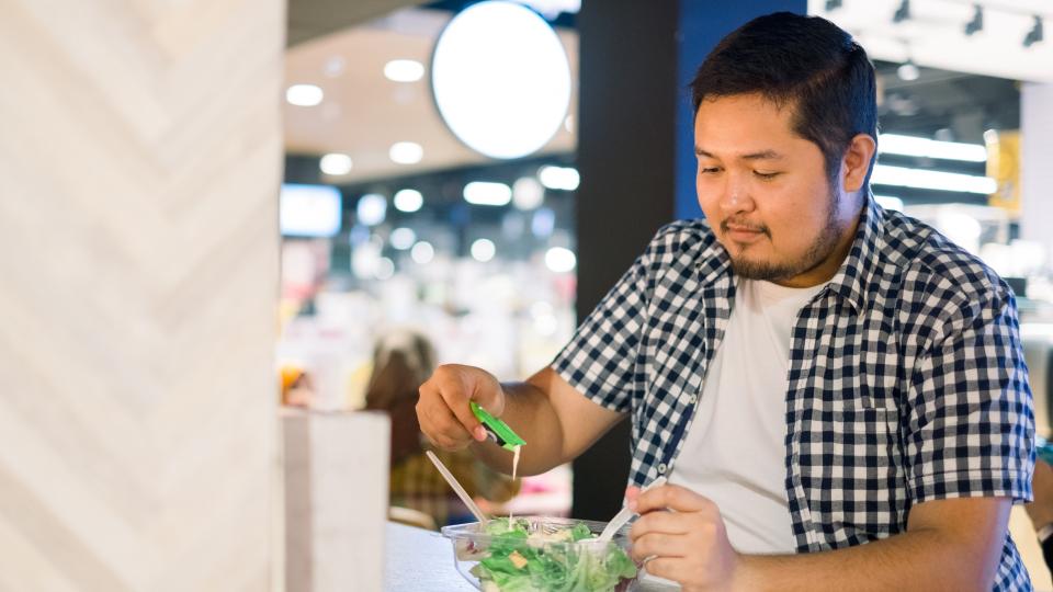 A man enjoying a salad at a restaurant.