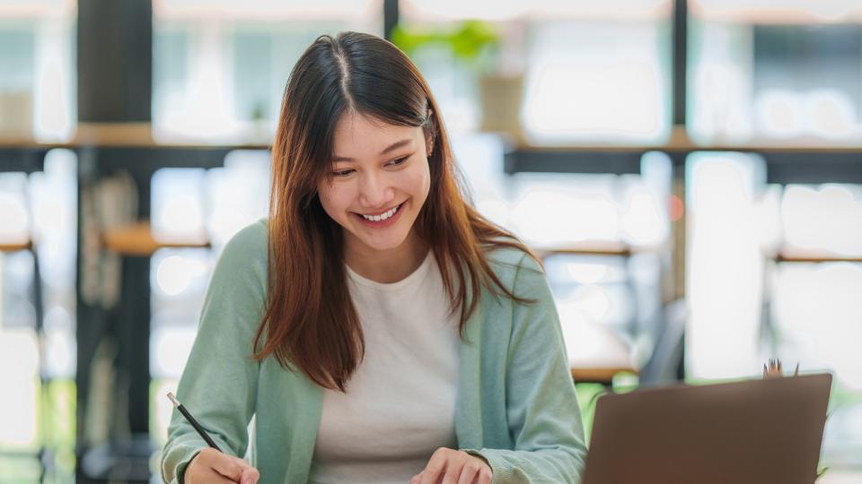 A woman happily working on her laptop.