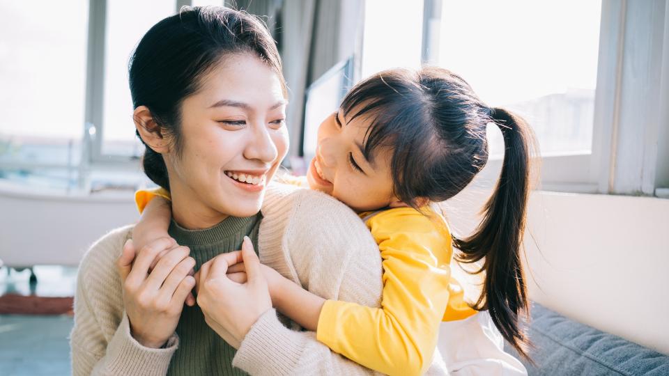 A heartwarming moment between a woman and a little girl as they share a warm embrace. Love and affection captured in a single image.