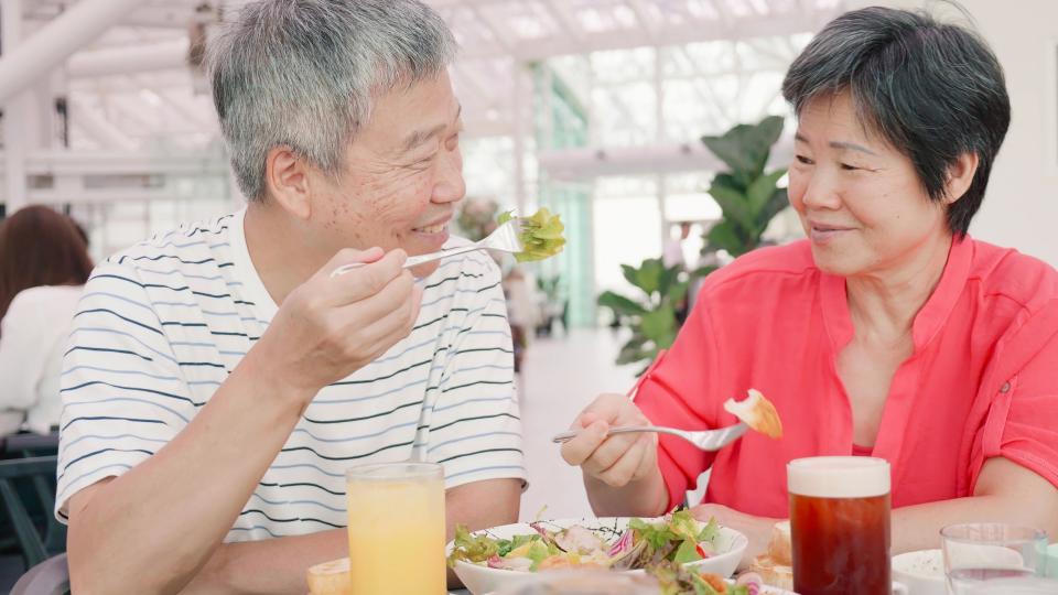 An elderly couple enjoying a meal together at a cozy restaurant.