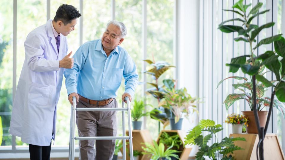 A man with walker discussing with doctor in hospital.