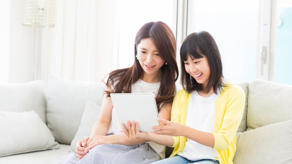 Mother and daughter looking at tablet screen.