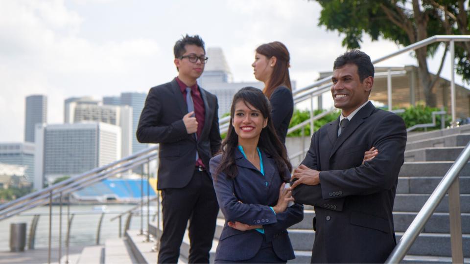 A group of professionals posing on steps, showcasing teamwork and success in the business world.