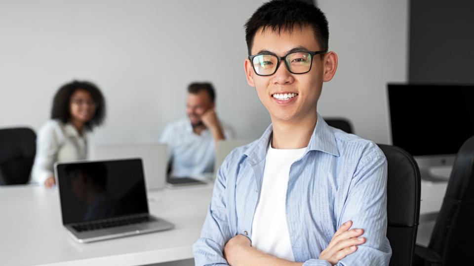 A man with glasses working on laptop