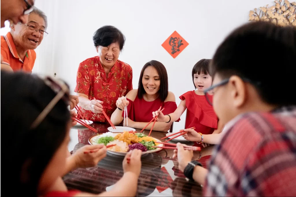 Stay Healthy During the Chinese New Year - A happy family enjoying a meal together at a table filled with delicious food.