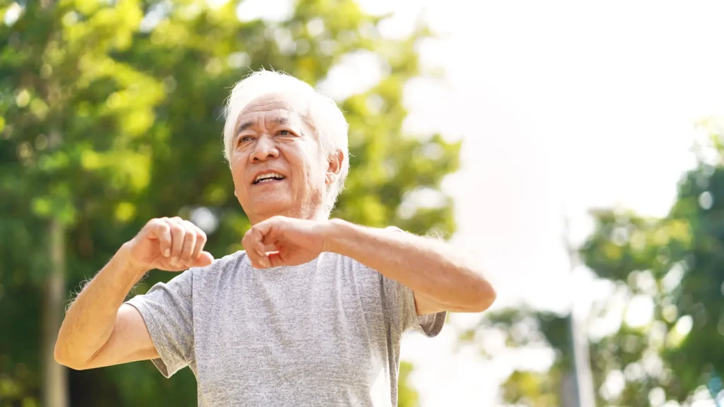 An older man stretching his arms, feeling refreshed and energized.