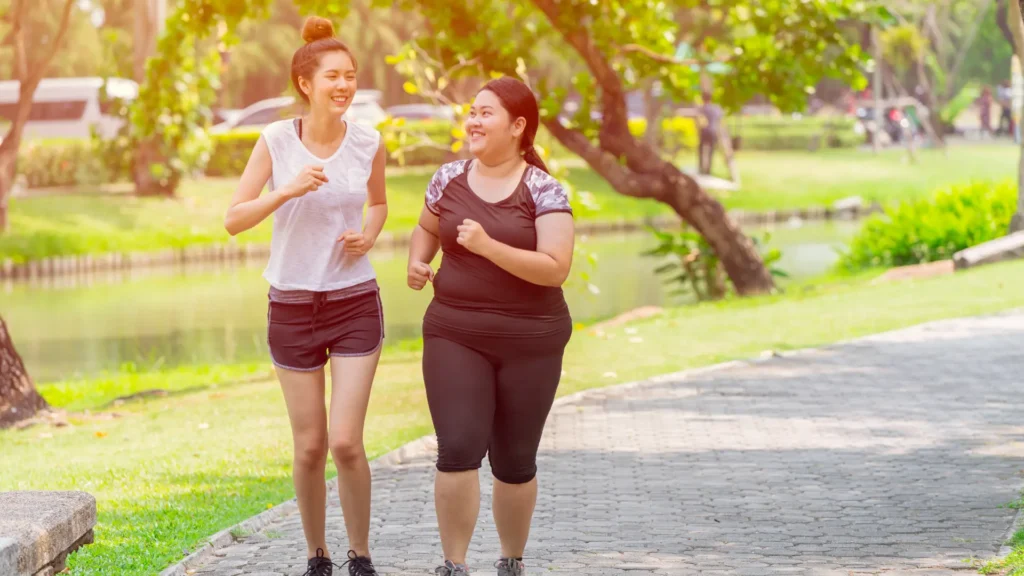 Two women jogging in a park, enjoying the fresh air and staying fit.