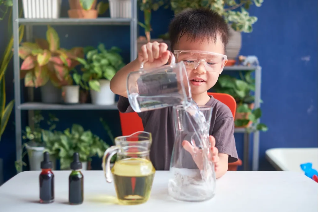 A young boy carefully pours liquid into a glass, demonstrating his focus and precision.