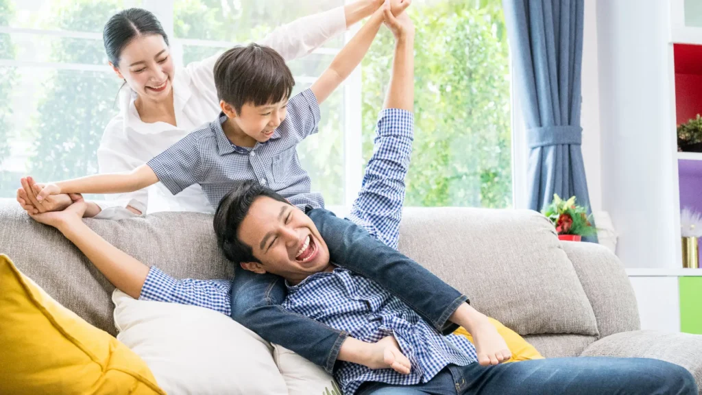 A joyful family of three enjoying quality time together on a cozy couch.