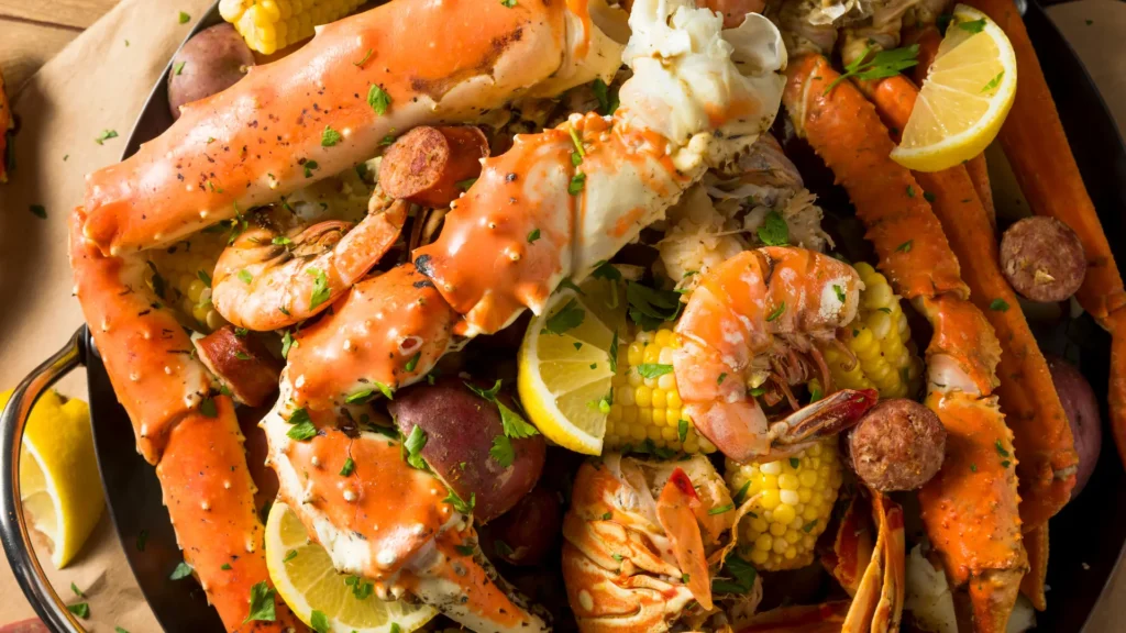 A delicious seafood feast with crab legs, corn, and potatoes cooked to perfection in a pan. Yum!
