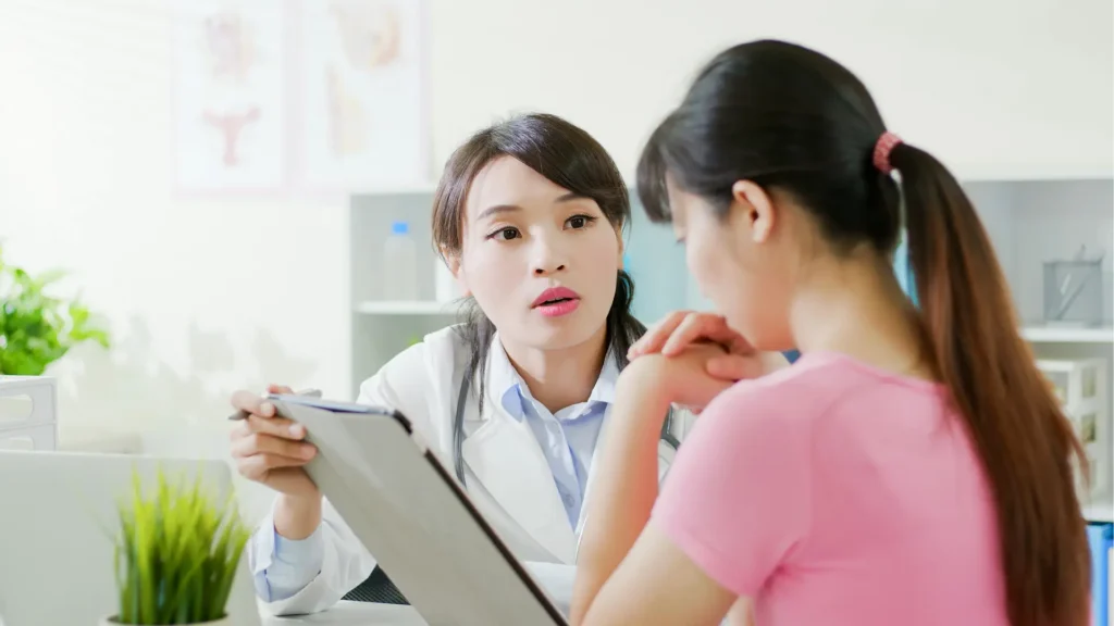Woman discussing health with doctor at desk. Hypersomnia