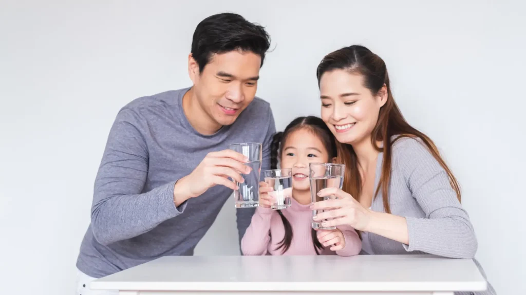 A family happily hydrating together, enjoying a refreshing moment while drinking water.