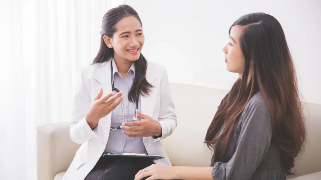 A woman discussing her health with her doctor, seeking professional advice and guidance.