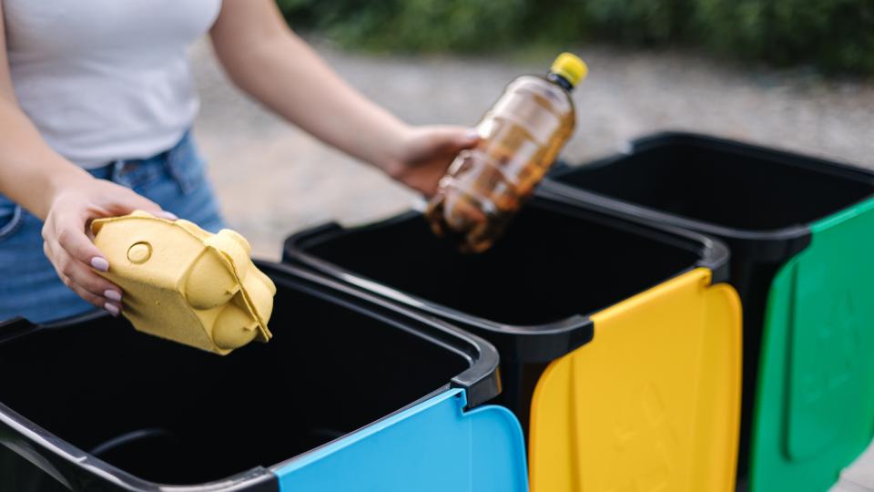 Person disposing plastic bottle in trash can. Safety Hazards in Your Home