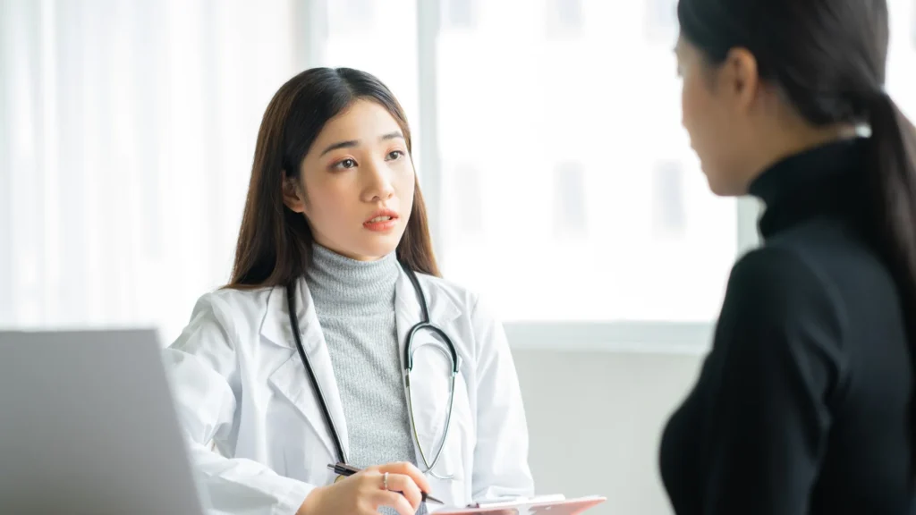 A woman discussing her health concerns with a doctor in a professional setting.