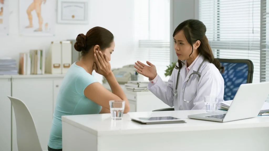 A woman discussing with a doctor in an office. Stroke Symptoms