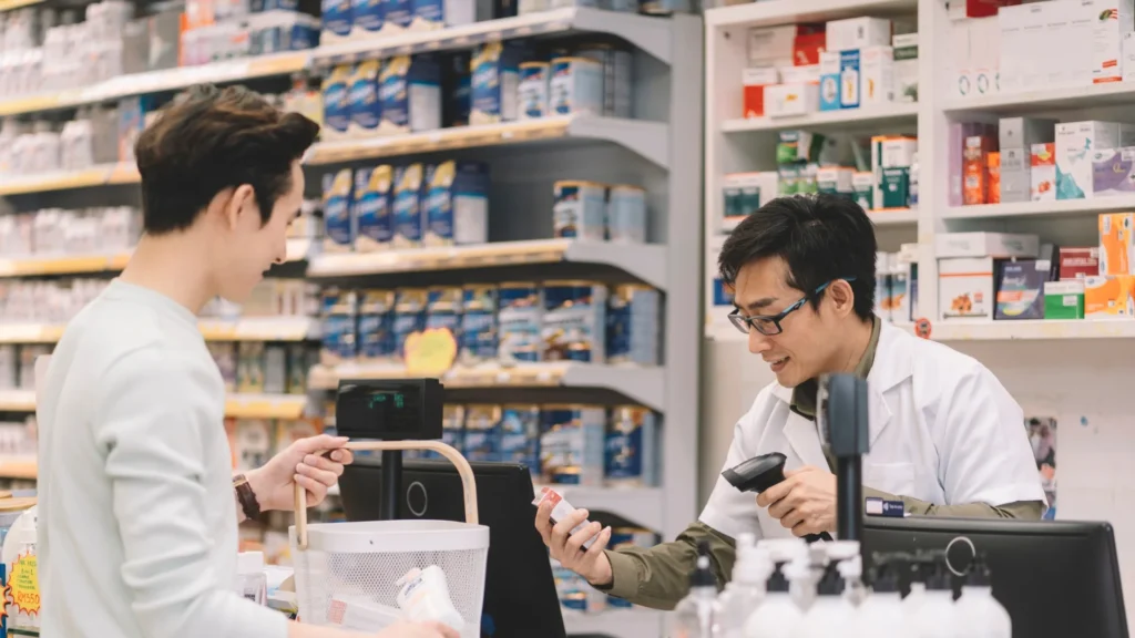 A pharmacist assisting a customer in a pharmacy shop.