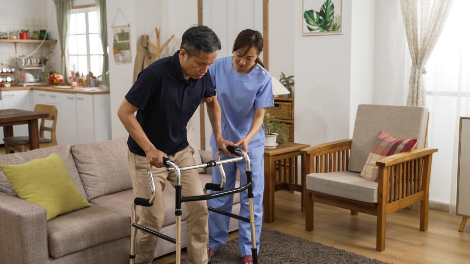 A man and woman assisting each other with a walker.
