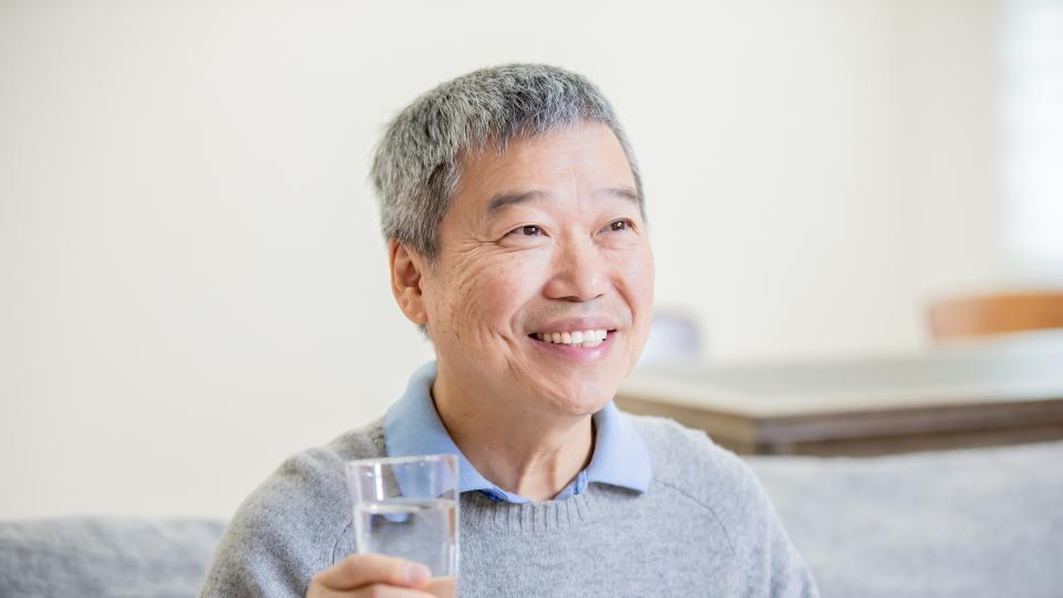 A man holding a glass of water.