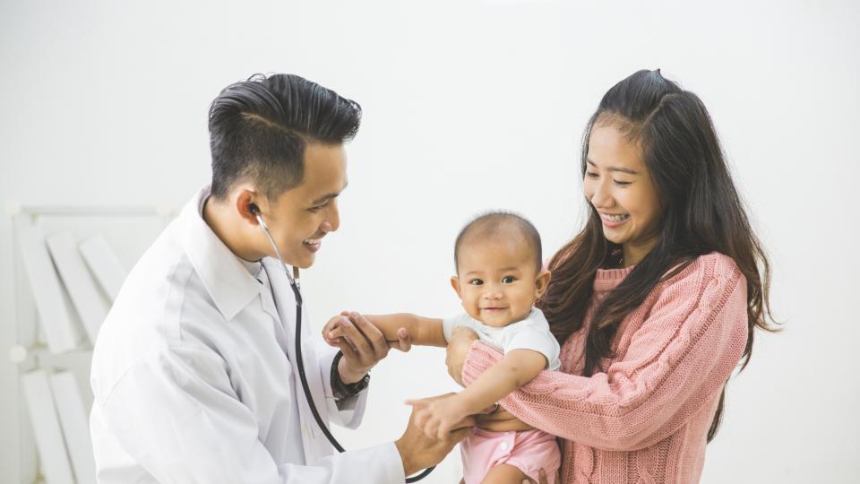 A doctor examining baby's heart.