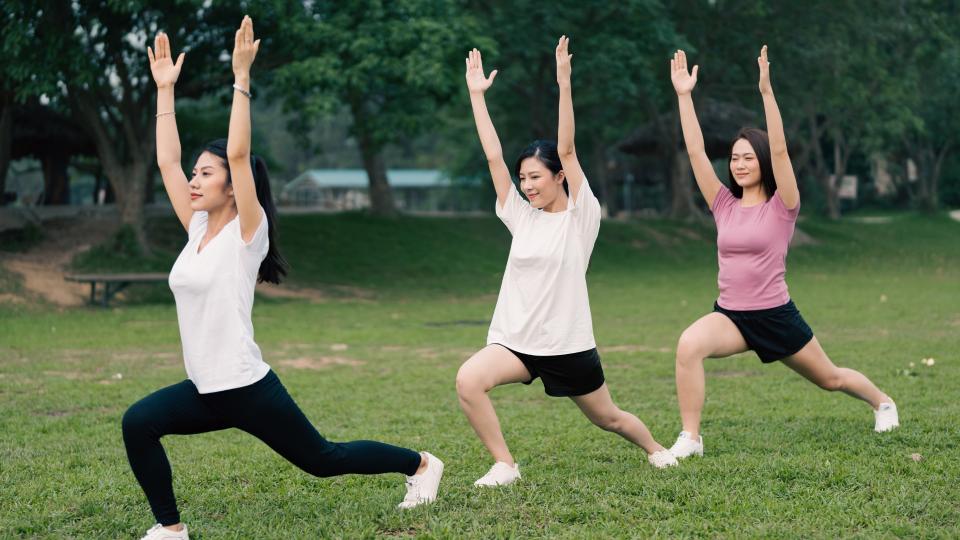 Group of women meditating and stretching during outdoor yoga session. Exercise
