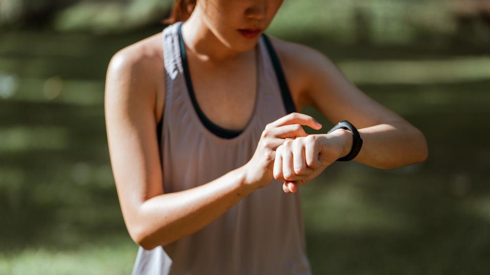 A woman looking at her wrist watch, fitness tracker.