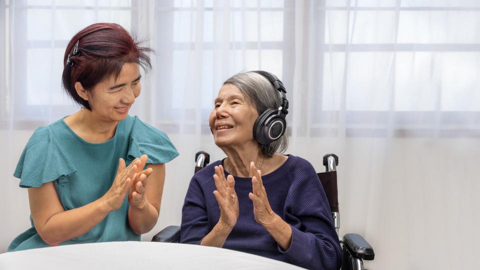 A woman in a wheelchair conversing with an older woman. Dementia