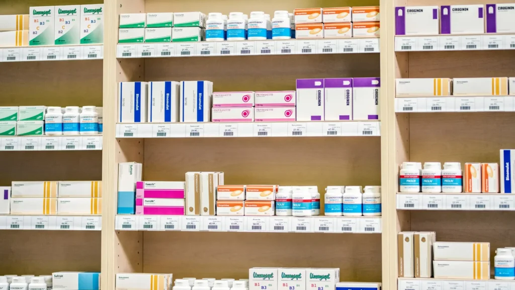 Assorted medications and products neatly arranged on pharmacy shelves.
