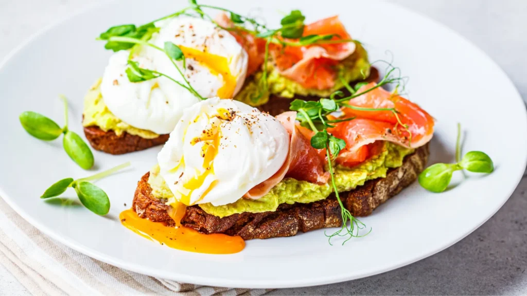 Two slices of toast topped with creamy avocado and perfectly cooked eggs. A delicious and nutritious breakfast option.