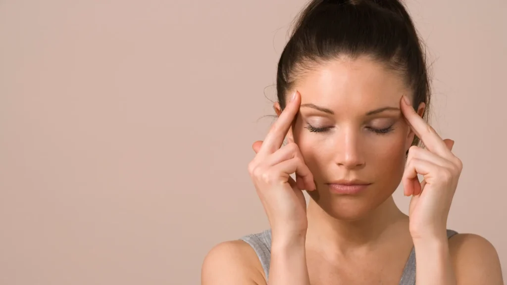 Stressed woman with hands on head.