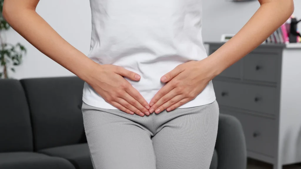 A pregnant woman gently cradling her belly with both hands, radiating a sense of care and anticipation.