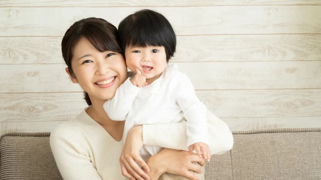 Mother and child sitting on couch, smiling and looking at each other lovingly.