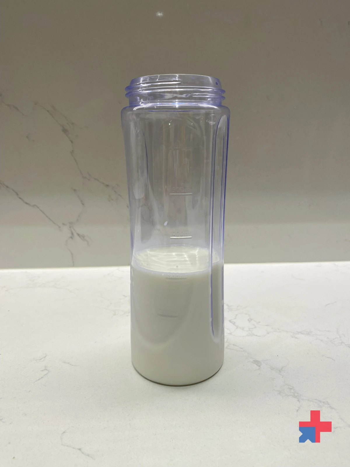 Bottle partially filled with milk on a white kitchen countertop
