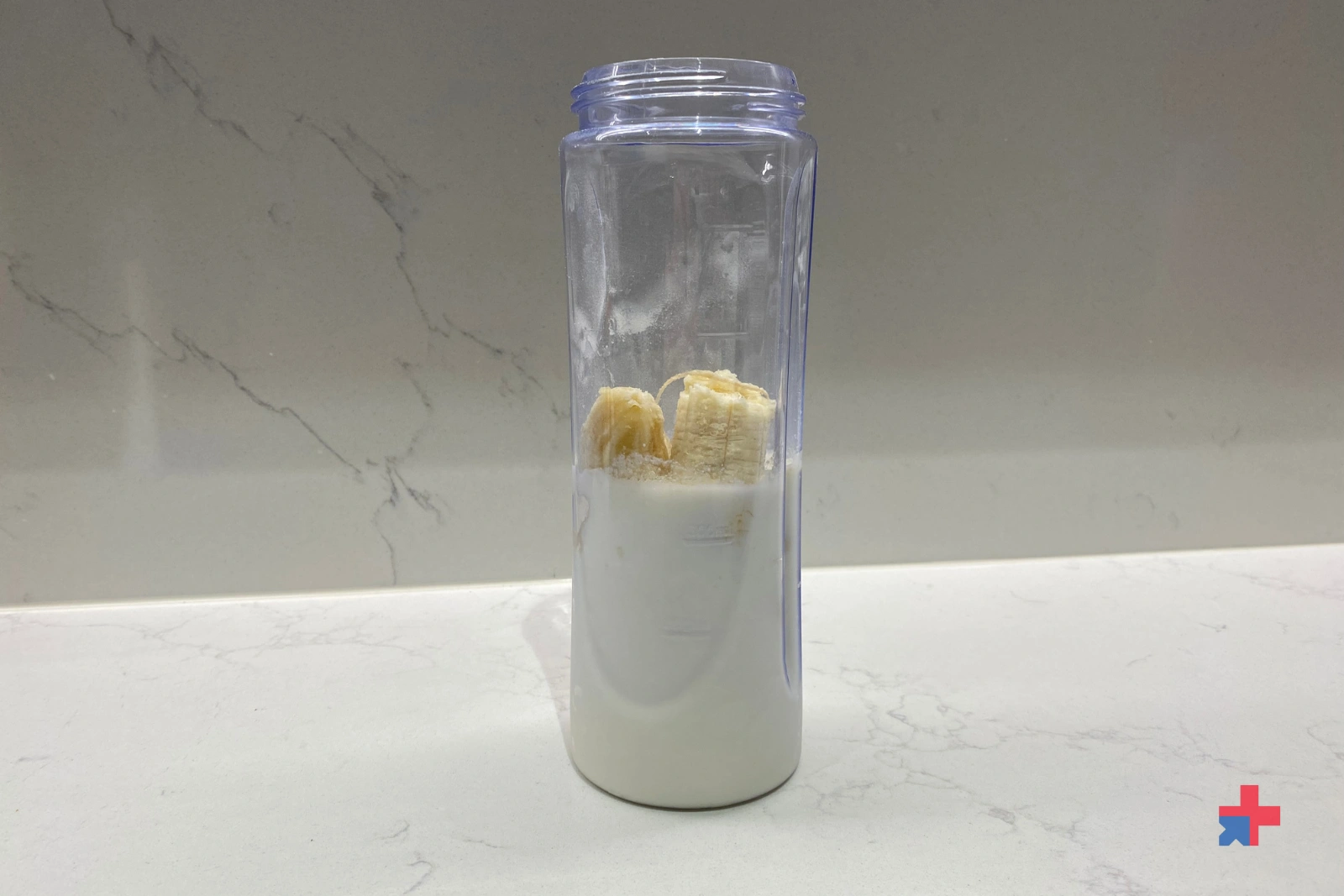 A bottle with the muscle nation daily shake, milk and one banana. 