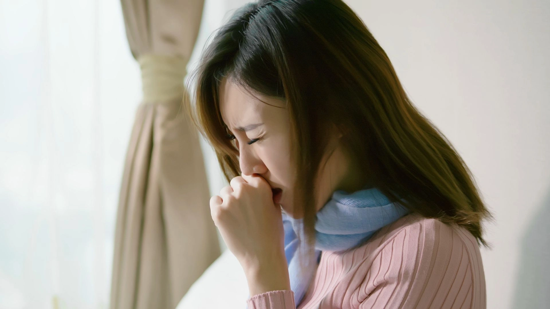 Woman suffering from severe coughing fit, a common symptom of whooping cough (pertussis). Persistent coughing can lead to breathing difficulties, especially in adults and children in Singapore.