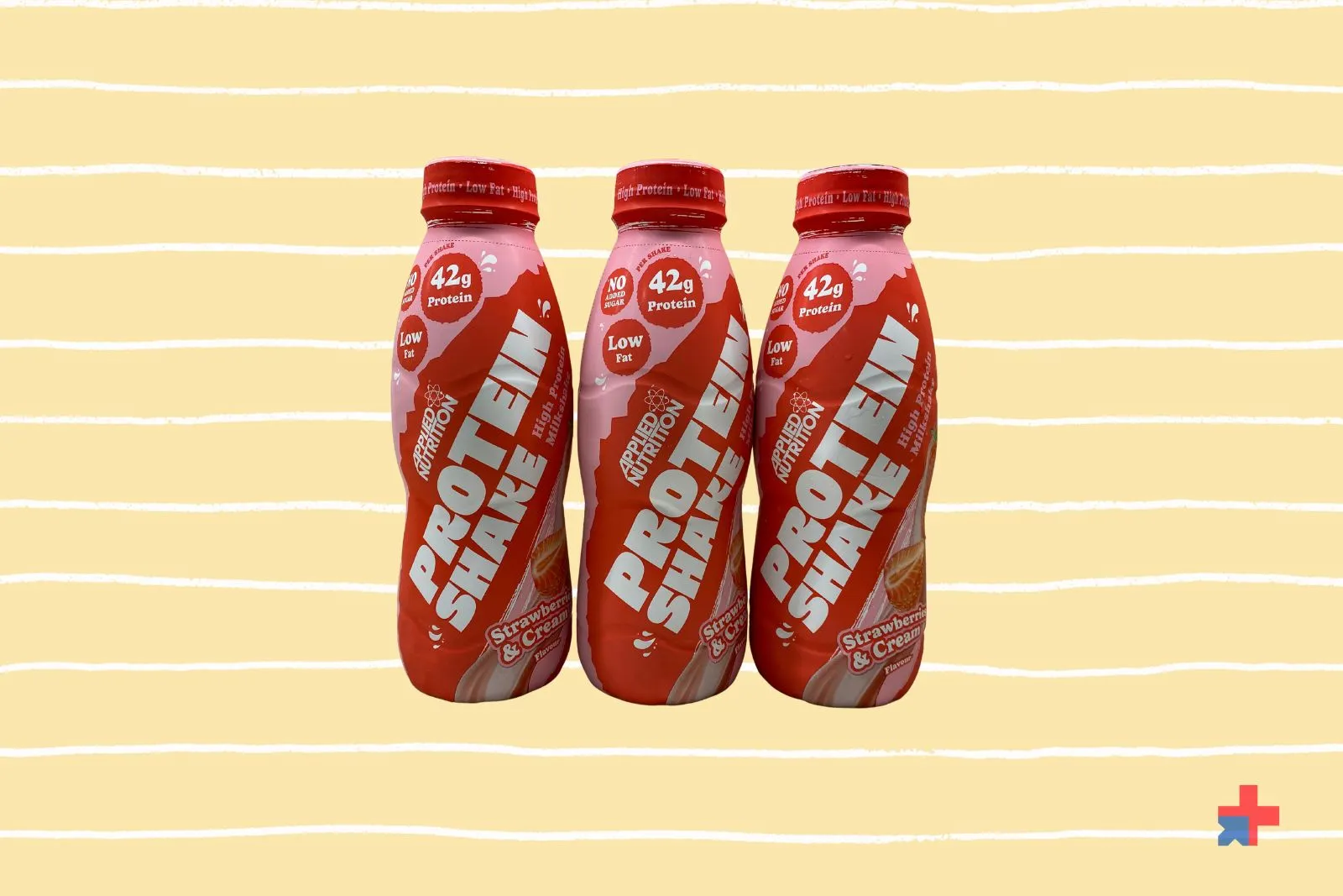 Three bottles of Applied Nutrition High Protein Shake in Strawberry & Cream flavour showing 42g protein, no added sugar and low fat claims